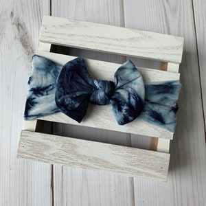 May include: A blue and white tie-dye headband with a knotted bow.