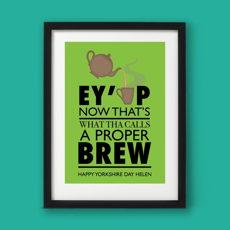 May include: A green and white poster with a black frame. The poster features a cartoon teapot pouring tea into a cup. The text reads "Ey' up now that's what tha calls a proper brew. Happy Yorkshire Day Helen."