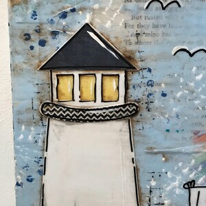 May include: A mixed media art piece featuring a lighthouse with a black roof, yellow windows, and a chevron-patterned balcony. The lighthouse is set against a textured blue and white background with printed text and hand-drawn bird silhouettes.