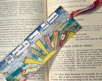 May include: Handmade bookmark with a colorful sunburst design and the text "All you need is love and sunsets." The bookmark is made of layered paper with a textured finish and a multi-colored tassel.