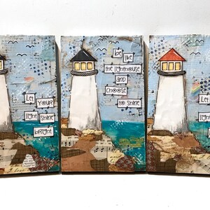 May include: A set of three rectangular wall art panels featuring mixed media collages of lighthouses on rocky shores. The panels include text that reads: Let your light shine bright and be like the lighthouse and choose to shine.