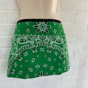 Può includere: Grembiule verde con stampa bandana, bordo nero e due tasche.