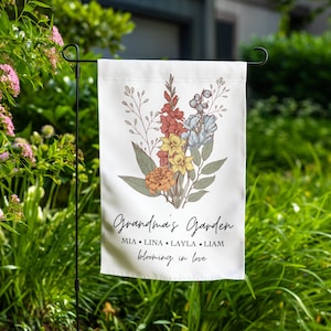 May include: A white garden flag with a floral design and the text "Grandma's Garden" with the names Mia, Lina, Layla, and Liam and the text "Blooming in love".