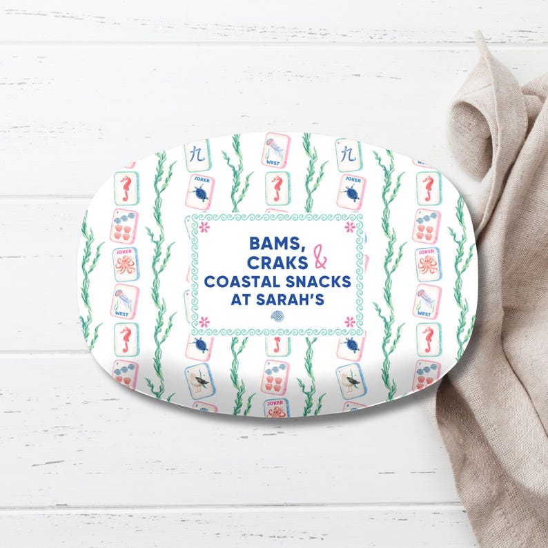 May include: An oval serving platter with a white background, featuring a repeating pattern of playing cards, seahorses, and seaweed. The center has text that reads "BAMS, CRAKS & COASTAL SNACKS AT SARAH'S".