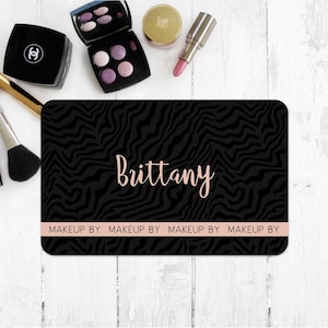 May include: Black and white zebra print makeup bag with the name "Brittany" and the text "Makeup By" repeated four times.