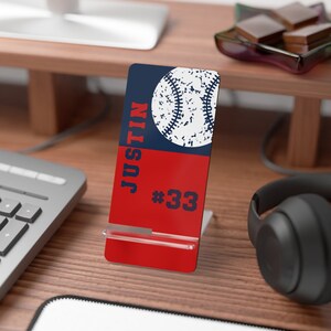 May include: A red and blue phone stand with a baseball graphic and the text "Justin #33".