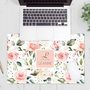 May include: A pink and white floral desk mat with a personalised name, "LEANNE", in a pink square with a cursive "L" above it.
