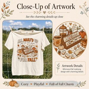 May include: A cream-colored t-shirt featuring a graphic print with the text ALL MAHJ'D UP just one more game FOR FALL. The illustration includes a mahjong set, a coffee mug, a French press, pumpkins, and autumn leaves in shades of orange and brown.