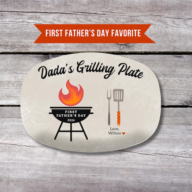 May include: An oval-shaped plate with the text "Dada's Grilling Plate" and "First Father's Day 2026". The plate features a grill graphic with a flame, a fork, and a spatula. The text "Love, Willow" is also included.