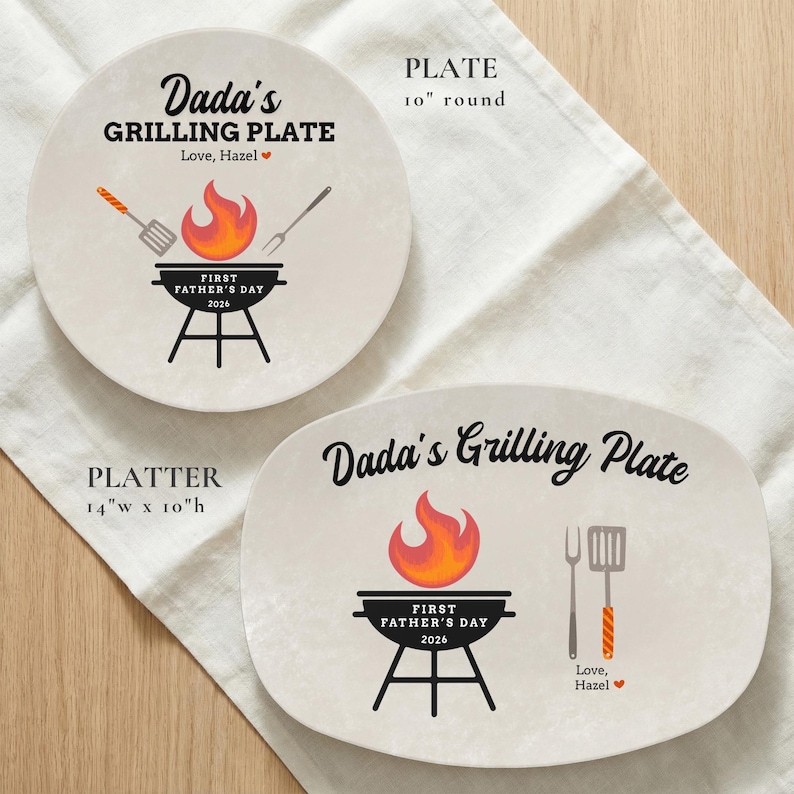 May include: Two beige ceramic plates with grilling-themed designs. One is round, 10 inches in diameter, and the other is an oval platter, 14 inches wide and 10 inches high. Both feature the text "Dada's Grilling Plate" and "First Father's Day 2026".