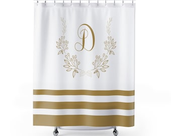 May include: White shower curtain with gold stripes and a gold floral wreath with the letter "D" in the center.