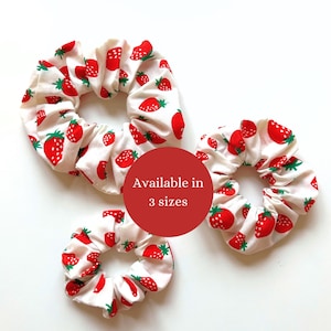 Peut inclure: Trois chouchous blancs avec un imprimé de fraises rouges. Les chouchous sont disponibles en trois tailles.