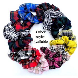 May include: A collection of colorful plaid scrunchies in various patterns, including red, black, white, blue, green, yellow, and pink. The text "Other styles available" is written in the center of the image.