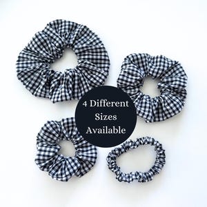May include: Four black and white gingham scrunchies in different sizes.  "4 Different Sizes Available" text is in the center of the image.