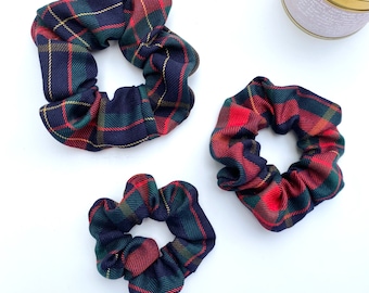 May include: Three plaid scrunchies in different sizes. The scrunchies are made of a red, green, and blue plaid fabric.