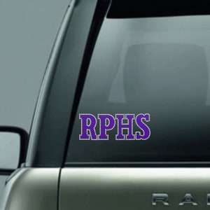 May include: Purple and white vinyl decal with the text "RPHS" on a car window.