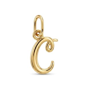 May include: A polished gold-tone metal pendant shaped as the uppercase letter C in a cursive script font. The charm features a smooth, reflective surface and includes a small, circular jump ring at the top for attachment to a chain or necklace.