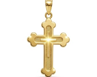 May include: A gold-colored pendant in the shape of a cross. The cross has rounded edges and a textured surface. The bail is a simple loop. The pendant is displayed against a white background.