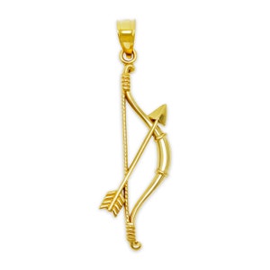 May include: A gold-toned pendant featuring a detailed bow and arrow design. The bow is curved and has a textured surface, while the arrow is straight and has a pointed tip.