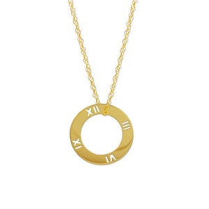 Puede incluir: Un collar de oro con un colgante circular con números romanos.