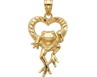 May include: A gold pendant featuring a frog positioned in front of a heart-shaped frame. The heart frame has a textured, diamond-cut finish, while the frog has a smooth, polished surface. The pendant includes a small bail at the top for hanging.