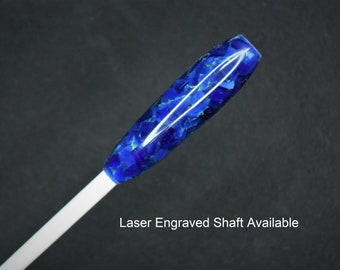 May include: A close-up of a blue and gold resin pen with a white shaft. The pen has a unique, marbled appearance. Laser Engraved Shaft Available.