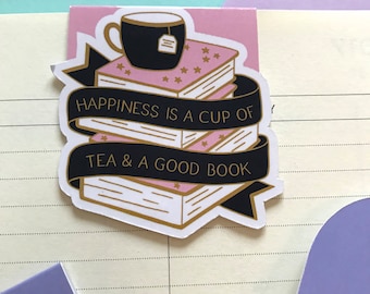 May include: A pink and black bookmark with a stack of books, a cup of tea, and the text "Happiness is a cup of tea & a good book".