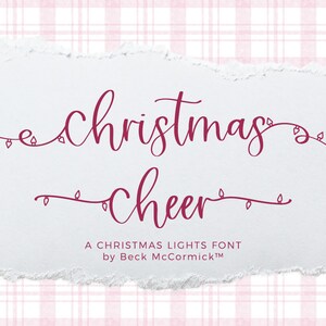 May include: A Christmas Lights font, a cursive font with the words "Christmas" and "cheer" in a burgundy color. The words are surrounded by a string of lights with bulbs. The text "A Christmas Lights Font by Beck McCormick™" is below the words.