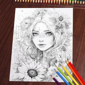 May include: Black and white illustration of a woman with long hair and a floral crown, surrounded by flowers. Colored pencils in various colors are arranged around the artwork on a wooden surface. The artwork is a coloring page.
