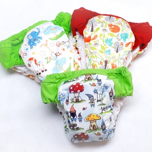 May include: Three reusable cloth diapers with different colorful patterns. One diaper has a red, white, and green floral pattern, another has a white background with a zebra, giraffe, and elephant print, and the third has a white background with a mushroom and gnome print.