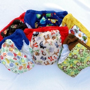 May include: A collection of six colorful reusable cloth diapers with various animal and cartoon prints. The diapers are made of soft, breathable fabric and are designed to be comfortable for babies.