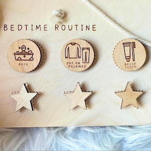May include: Wooden bedtime routine chart with the words "BEDTIME ROUTINE" at the top. The chart includes three circular wooden icons with illustrations for bath, pajamas, and brushing teeth, along with three star-shaped wooden pieces.