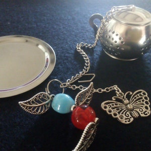 Unique teapot shape infuser and tray, hand crafted heavy butterfly pendant. High quality strainer, great gift idea for butterfly lovers.