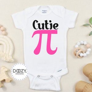 Pu&ograve; includere: Body bianco per neonato con testo nero che dice "Cutie Pi" con un simbolo pi rosa.