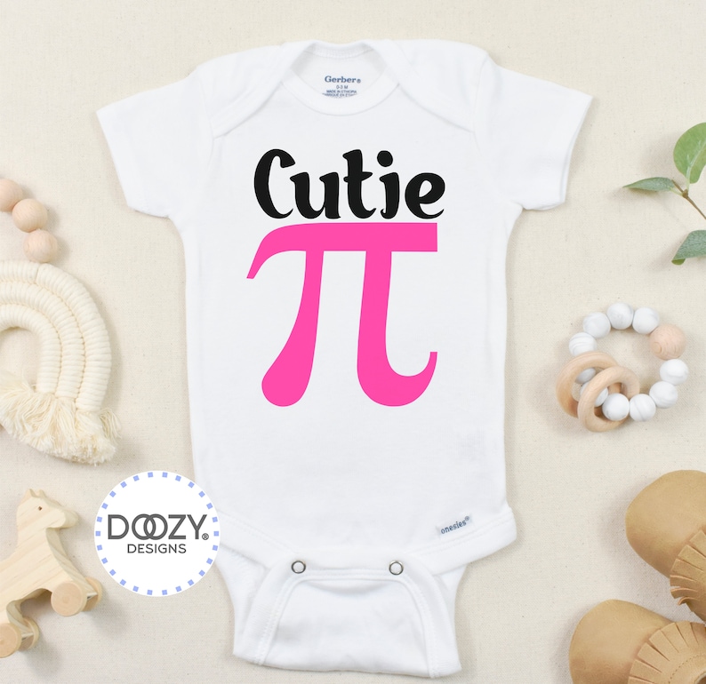 Pu&ograve; includere: Body bianco per neonato con testo nero che dice "Cutie Pi" con un simbolo pi rosa.