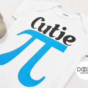 Pu&ograve; includere: Un body bianco per neonato con un simbolo pi blu e il testo "cutie pi" in nero. Il body &egrave; su uno sfondo bianco.