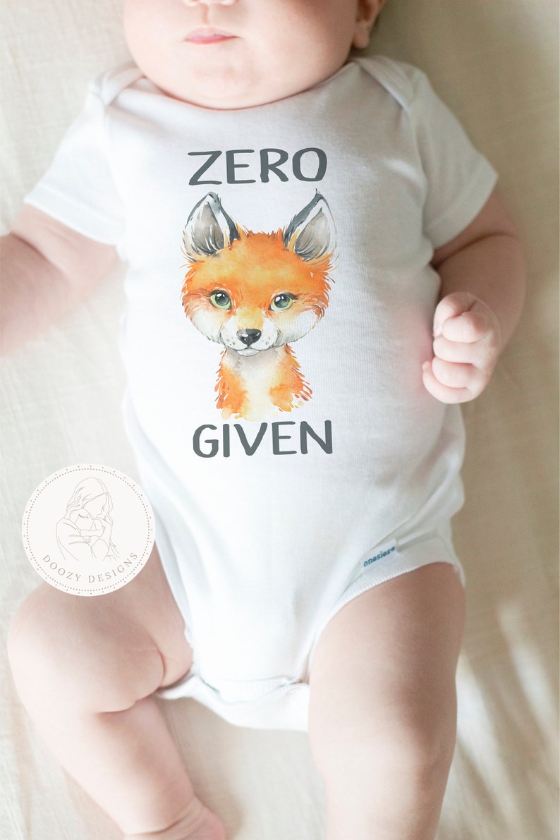 May include: White baby onesie with a fox illustration and the text "ZERO GIVEN".
