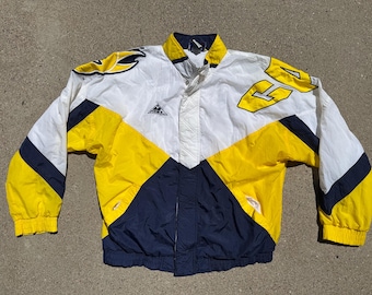 May include: A vintage Apex jacket in white, yellow, and navy blue. The jacket features a color-block design with yellow accents on the sleeves and body. The jacket has a button-up front and a collar. The jacket has a logo on the chest.