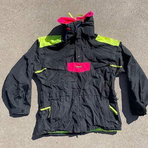 Puede incluir: Una chaqueta negra con detalles en verde neón y rosa. La chaqueta tiene un cuello alto y una cintura con cordón.