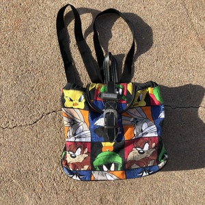 Mochila mini con solapa y cordón en la parte superior, con diseño de bloques de colores y personajes de Looney Tunes, de 1996