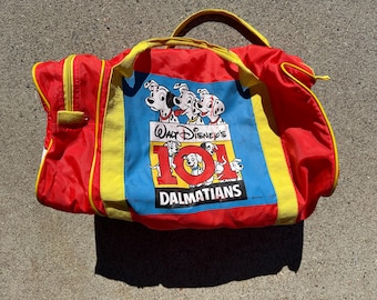 Peut inclure: Sac de voyage rouge et jaune avec un panneau bleu sur lequel est inscrit "Walt Disney's 101 Dalmatians" et une image de dalmatiens.