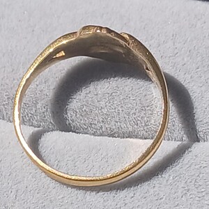 May include: A gold ring with a simple design. The ring is smooth and has a rounded band.