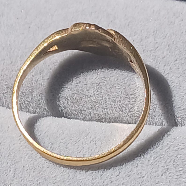 May include: A gold ring with a simple design. The ring is smooth and has a rounded band.