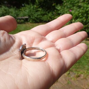 K&ouml;nnte beinhalten: Ein silberner Ring mit quadratischem Design. Der Ring ist auf der Innenseite der Ringschiene mit der Zahl "925" gekennzeichnet.