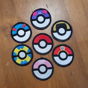May include: Eight embroidered iron-on patches featuring different Pokemon characters. The patches are circular and feature a variety of colors, including red, blue, yellow, green, and purple. Each patch has a different Pokemon character in the center, including Pikachu, Charmander, Bulbasaur, Squirtle, and more.