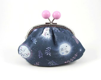 May include: A dark blue fabric coin purse featuring a repeating pattern of white sun faces with closed eyes and radiating lines, accented by small pink and purple sprigs. The purse has a silver metal kiss-lock frame with two round pink beads.