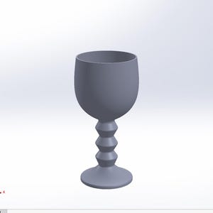 May include: A gray glass goblet with a unique, stepped stem. The goblet has a wide, round bowl and a flared base.
