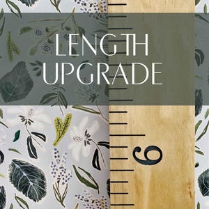 May include: A wooden ruler with black markings and the number "6" printed on it. The ruler is against a background of a floral pattern in shades of blue, green, and white. The text "LENGTH UPGRADE" is printed in black on a dark green background.