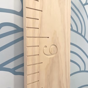 May include: A wooden growth chart with a number "6" carved into the wood. The chart has a series of lines for measuring height.