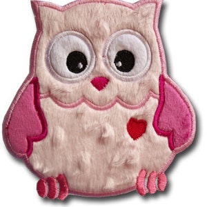 May include: Pink plush owl applique with a red heart on its chest. The owl has embroidered eyes and a pink beak.